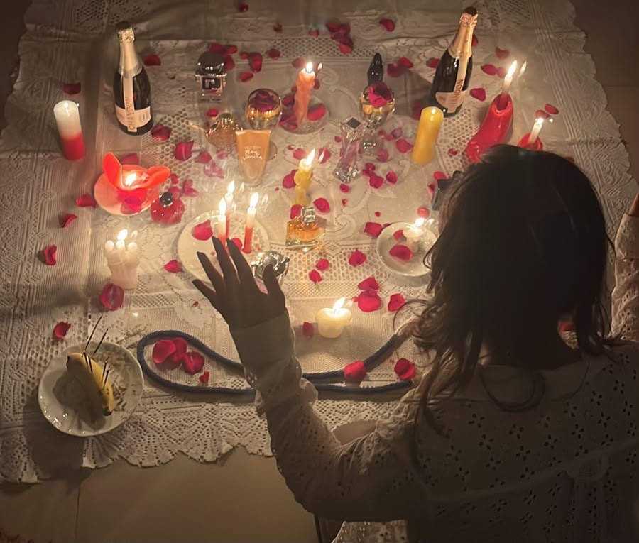 Mesa ritualística com velas, pétalas de rosa e oferendas de amor