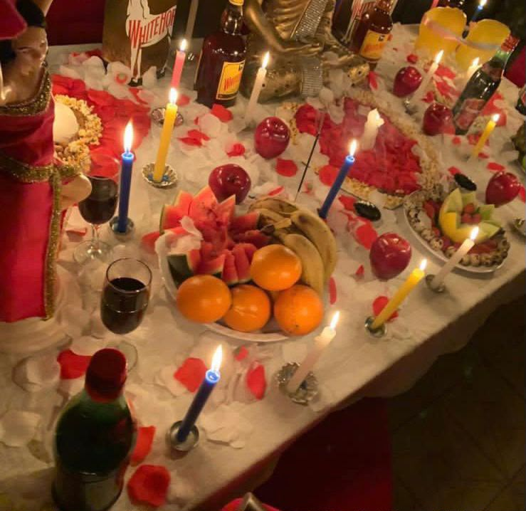 Altar de ritual do amor com velas, frutas e pétalas de rosa